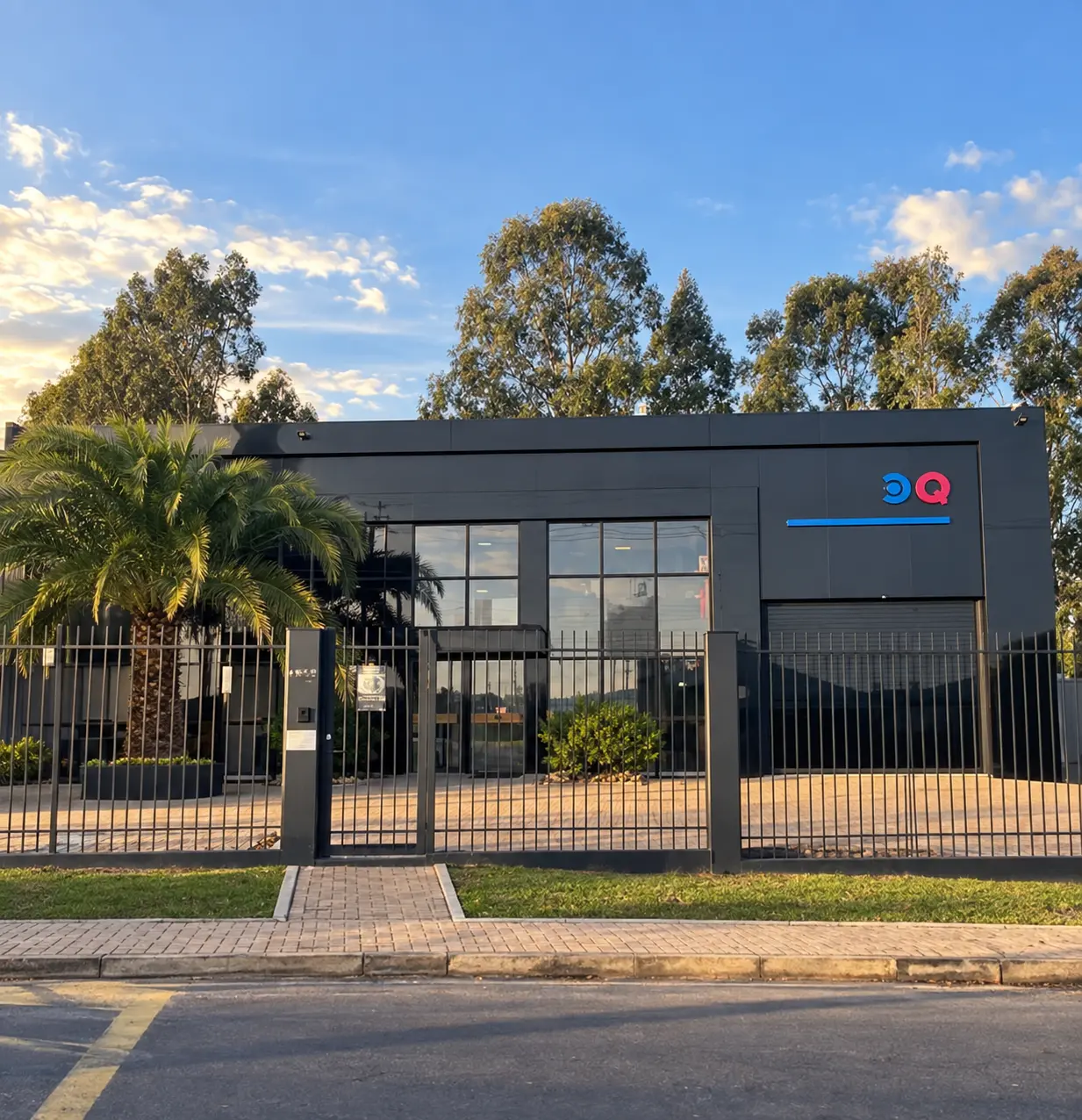 Corquímica facade, a dark building with the CQ logo, behind a fence
